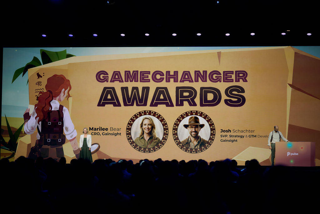 Josh at the podium on the Pulse stage beneath a Gamechanger Awards screen